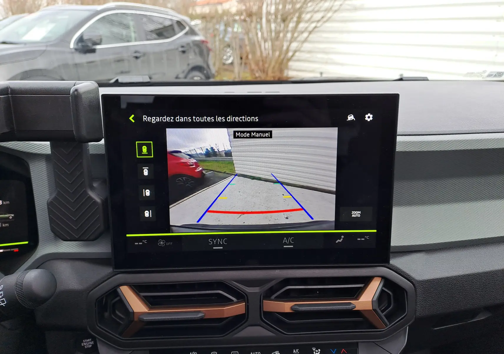 Vue intérieure du tableau de bord du Dacia Bigster noir nacré 2025, avec écran central affichant la caméra de recul en mode manuel.