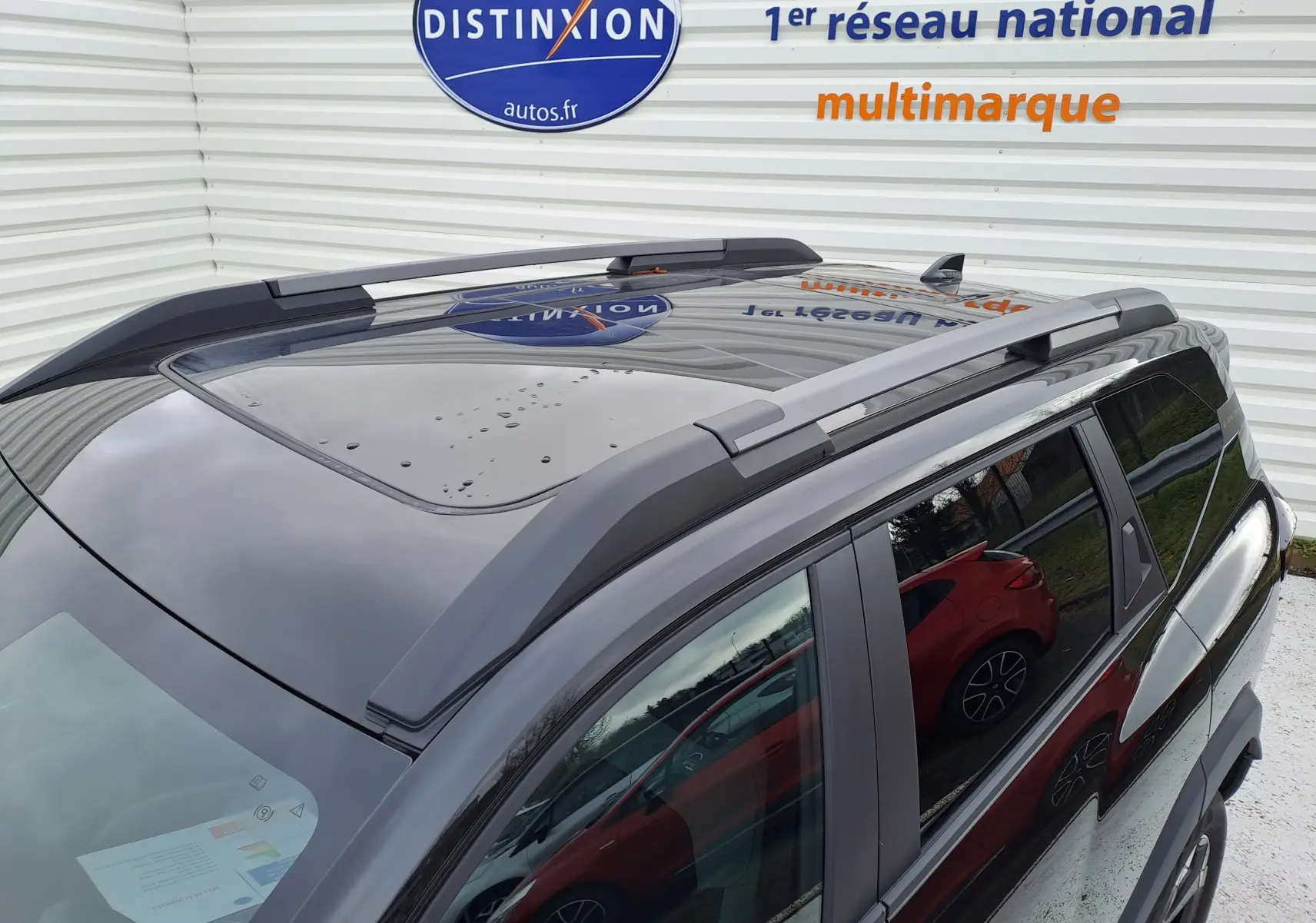 Vue en plongée du toit noir nacré du Dacia Bigster 2025, mettant en valeur le toit ouvrant et les barres de toit.