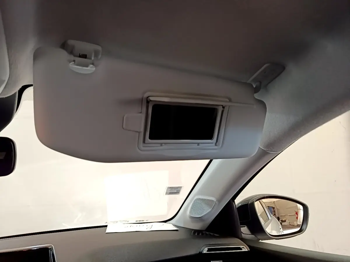 Intérieur du Peugeot 208 électrique blanc 2022, vue sur pare-soleil avec miroir et rétroviseur côté droit.
