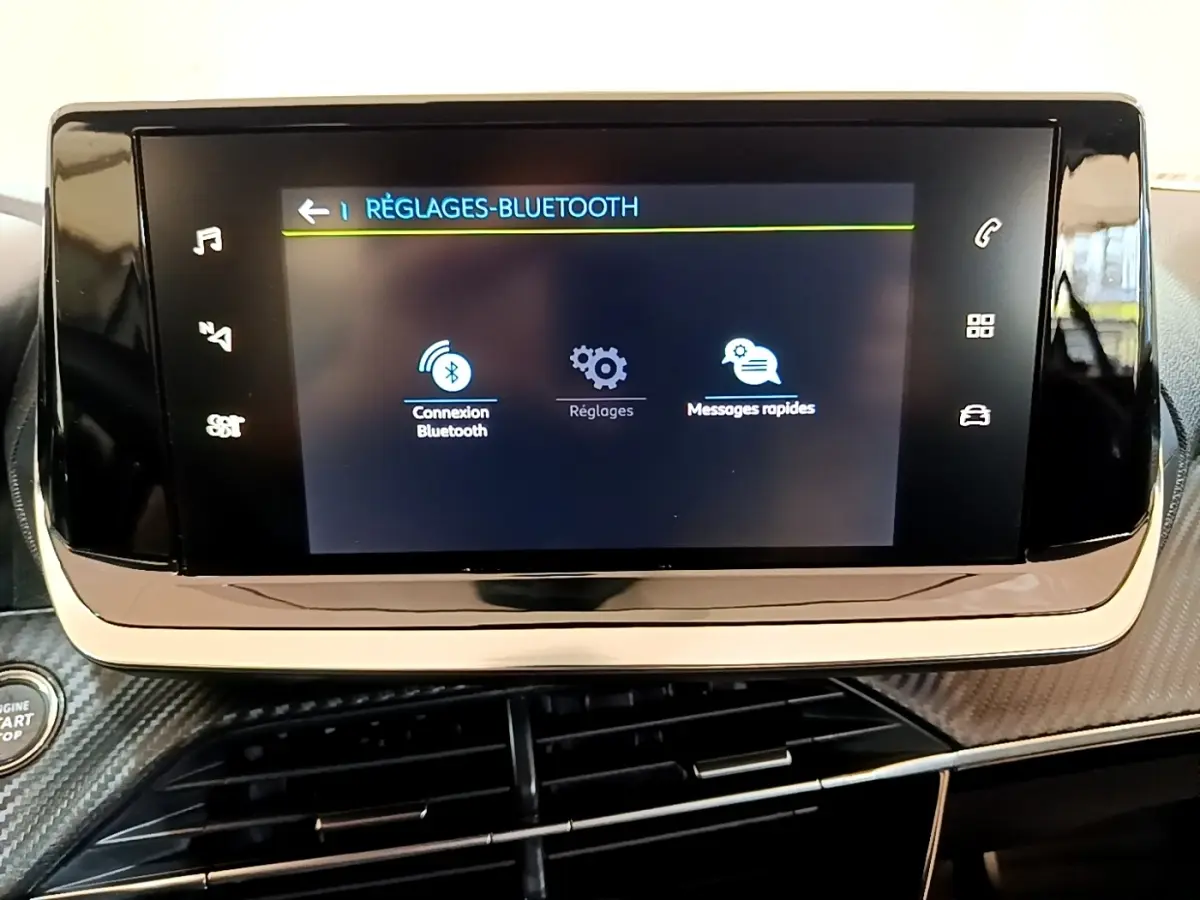 Écran tactile central affichant les réglages Bluetooth dans l’habitacle d’une Peugeot 208 électrique blanche.