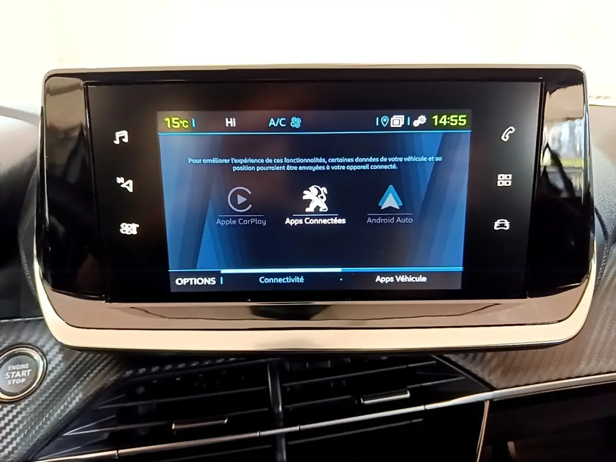 Écran tactile central affichant Apple CarPlay et Android Auto dans le tableau de bord d’une Peugeot 208 électrique blanche.
