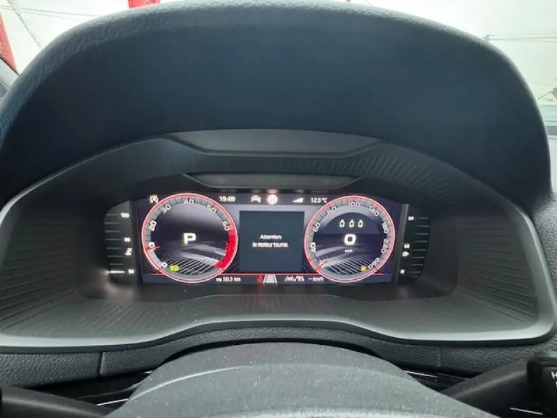 Vue rapprochée du tableau de bord numérique du Skoda Karoq 2025, affichage digital avec alertes moteur.