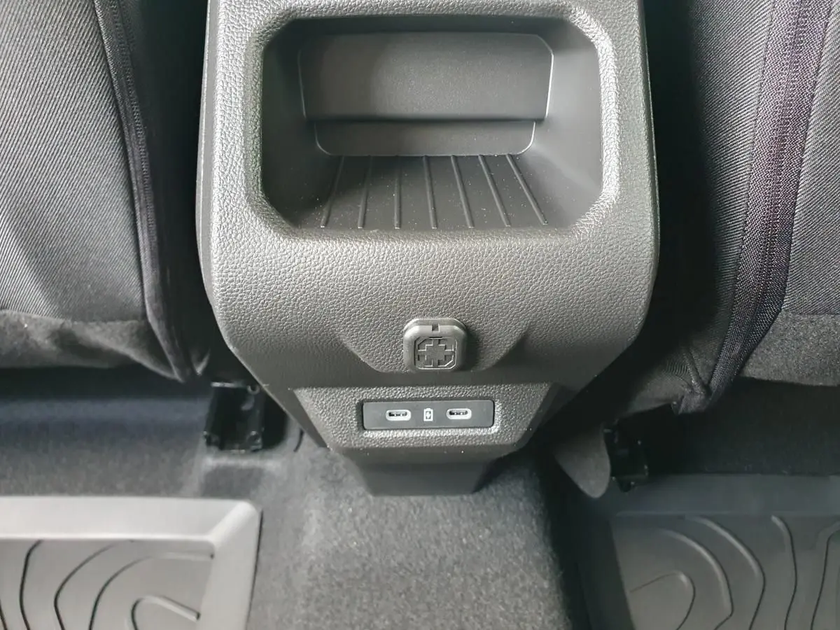 Vue rapprochée des prises USB type C à l'arrière de la console centrale du Dacia Duster gris schiste.
