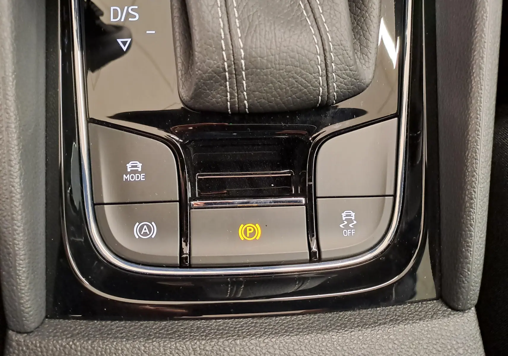 Gros plan sur la console centrale du Skoda Karoq 1.5 TSI 150 DSG7 Sportline avec levier de vitesse cuir et boutons de contrôle.