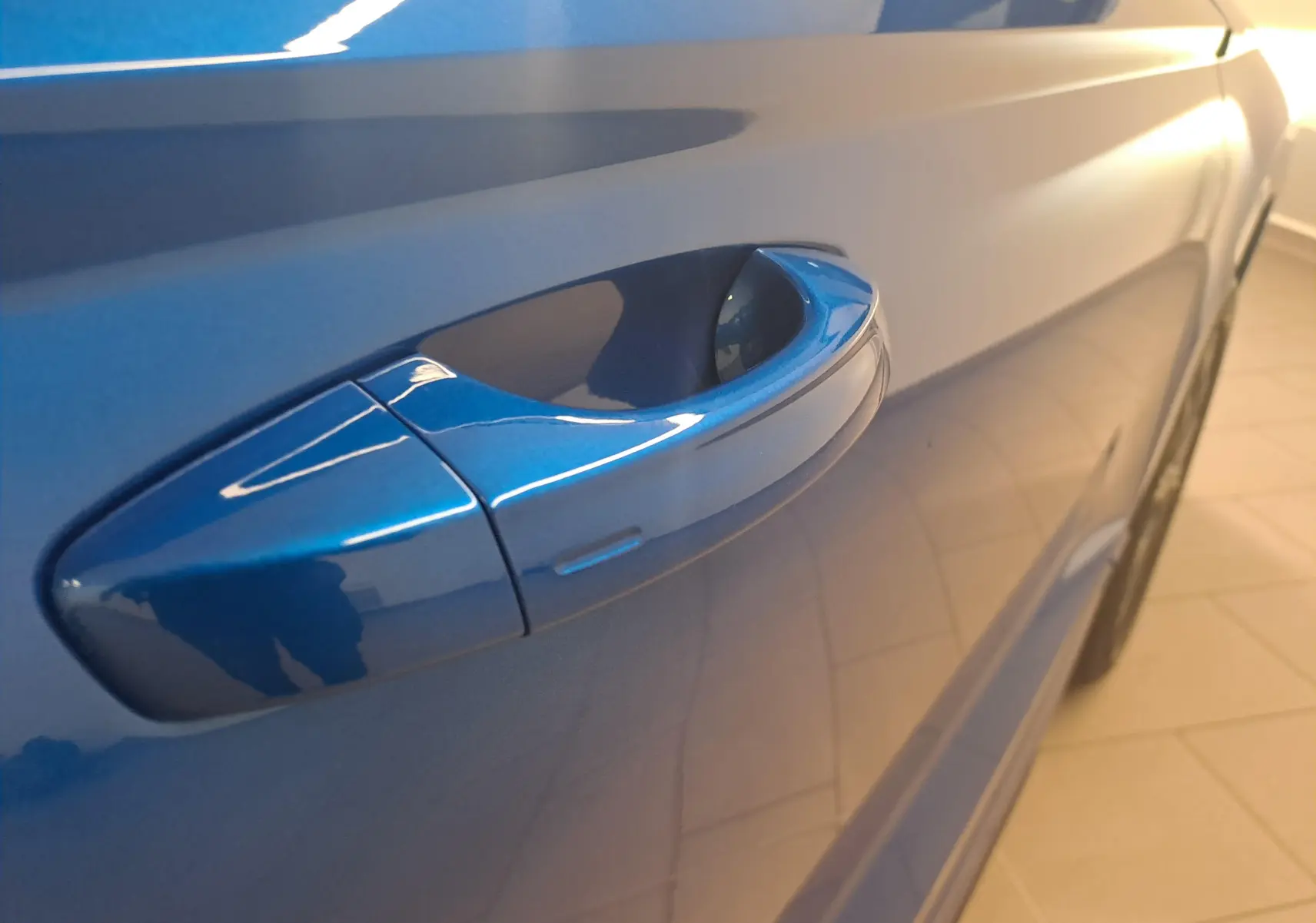 Poignée de porte côté gauche en gros plan sur Skoda Karoq Bleu RS 2025 avec peinture métallisée brillante.