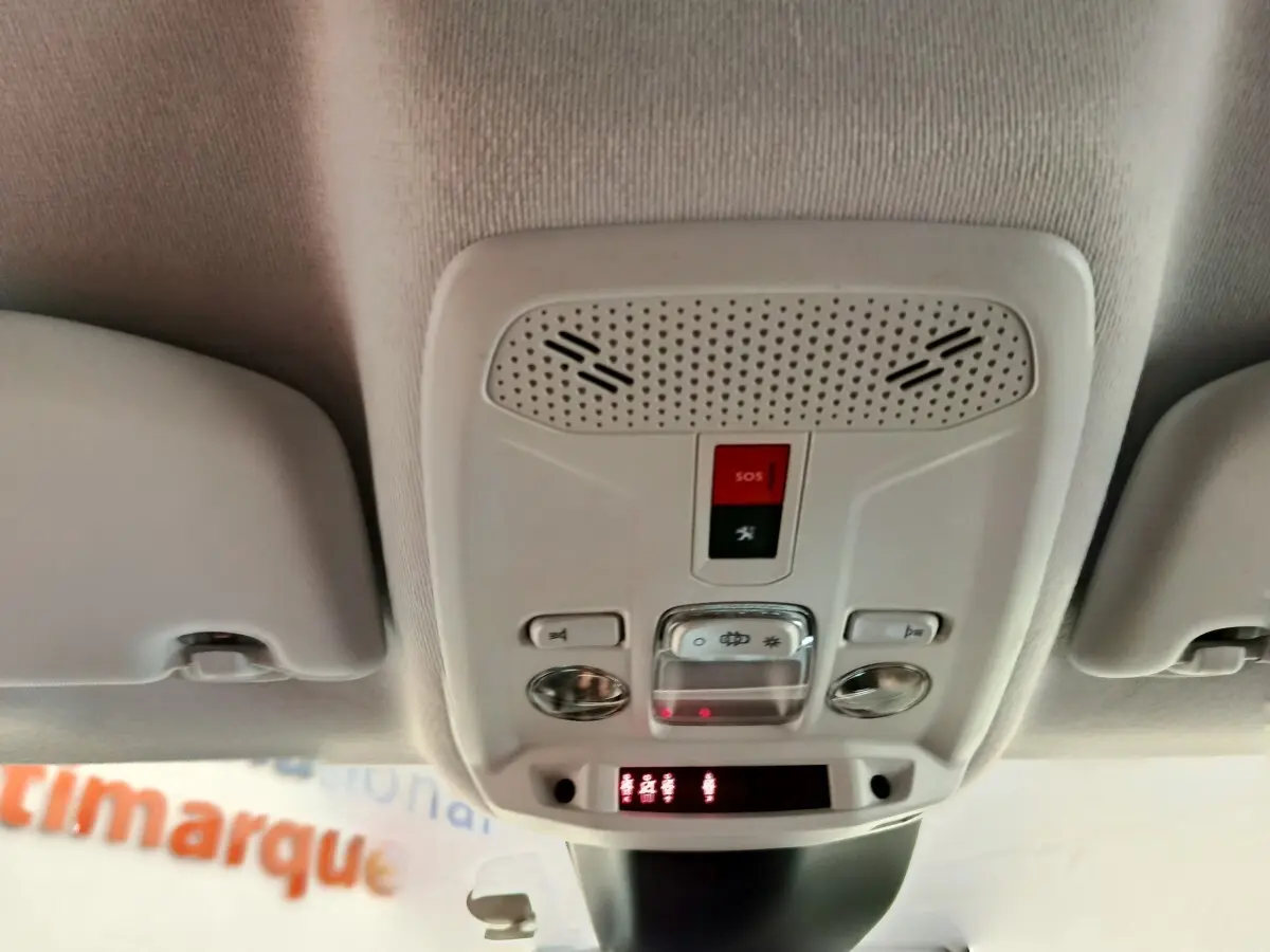 Vue intérieure en gros plan du plafonnier avec commandes et bouton SOS d'une Peugeot 208 noire de 2022.