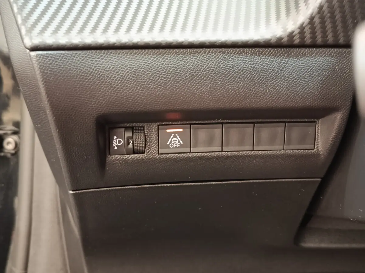 Gros plan sur les commandes de réglage des phares et d'activation de l'alerte de franchissement de ligne, intérieur noir.