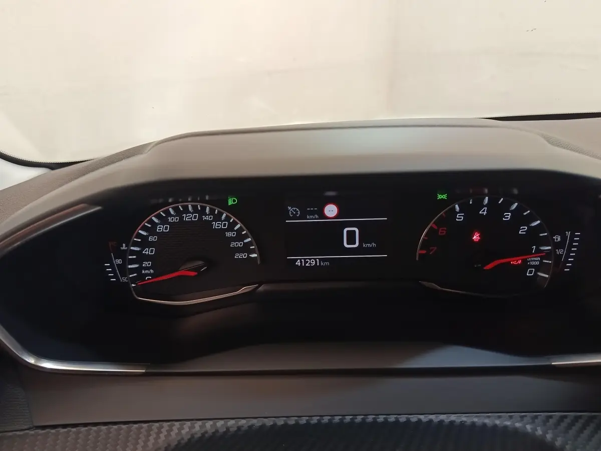 Tableau de bord de Peugeot 208 PureTech 100 2022, affichage numérique et compteurs analogiques noirs avec détails rouges.