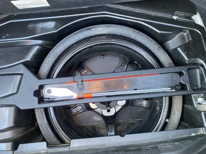 Gros plan sur la roue de secours et le cric dans le coffre d'une Mercedes Classe C Coupé Sport 220 CDI gris foncé métal 2008.