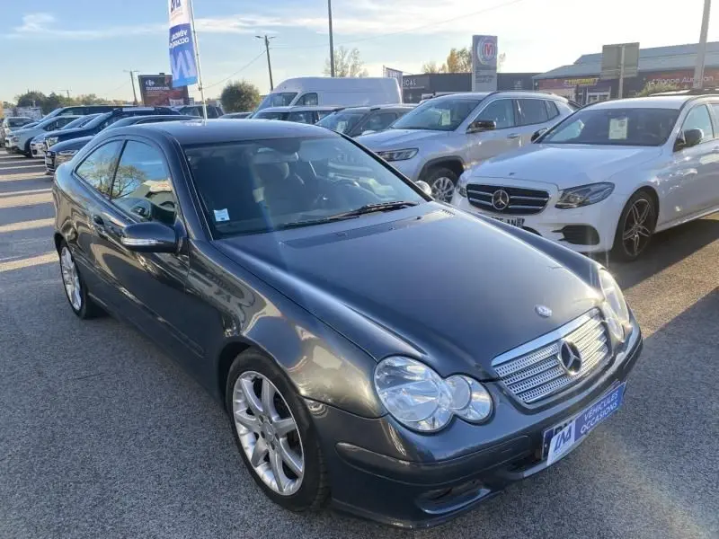 Mercedes Classe C Coupé Sport 220 CDI gris foncé métal vue 3/4 avant avec phares ronds et jantes alliage.