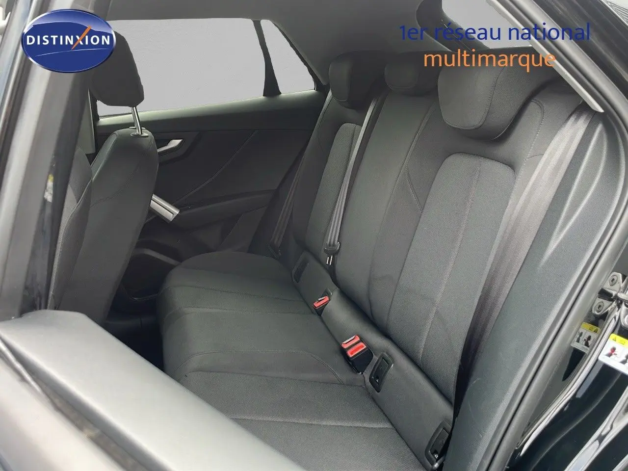Vue intérieure côté droit montrant la banquette arrière en tissu gris d’un Audi Q2 noir mito metal 2023.