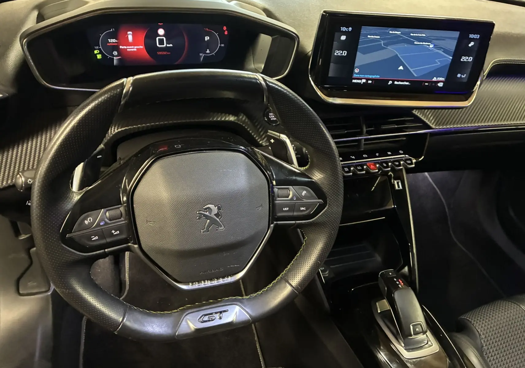 Vue intérieure centrée sur le volant GT et le tableau de bord numérique du Peugeot 2008 noir avec écran tactile GPS.