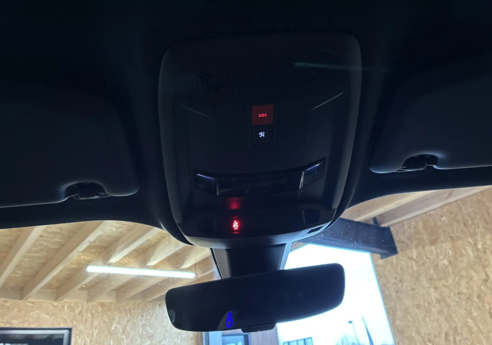 Vue intérieure du plafond et du rétroviseur d'une Peugeot 2008 GT Line noire de 2020, avec bouton SOS éclairé en rouge.