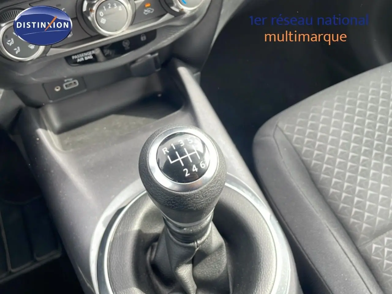 Gros plan sur le levier de vitesse manuel noir dans l'habitacle gris foncé du Nissan Juke 2023.