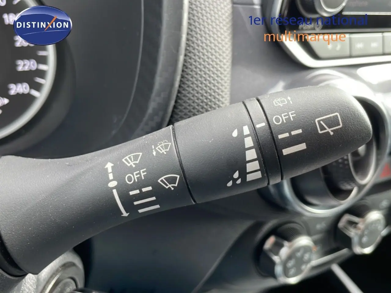 Gros plan sur la commande des essuie-glaces du Nissan Juke noir perle métal, intérieur gris foncé visible en arrière-plan.