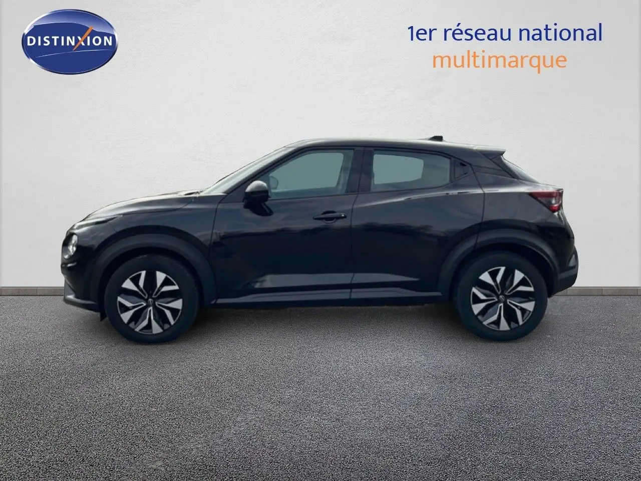 Profil côté gauche du Nissan Juke noir perle 2023 avec jantes au design bicolore distinctif.