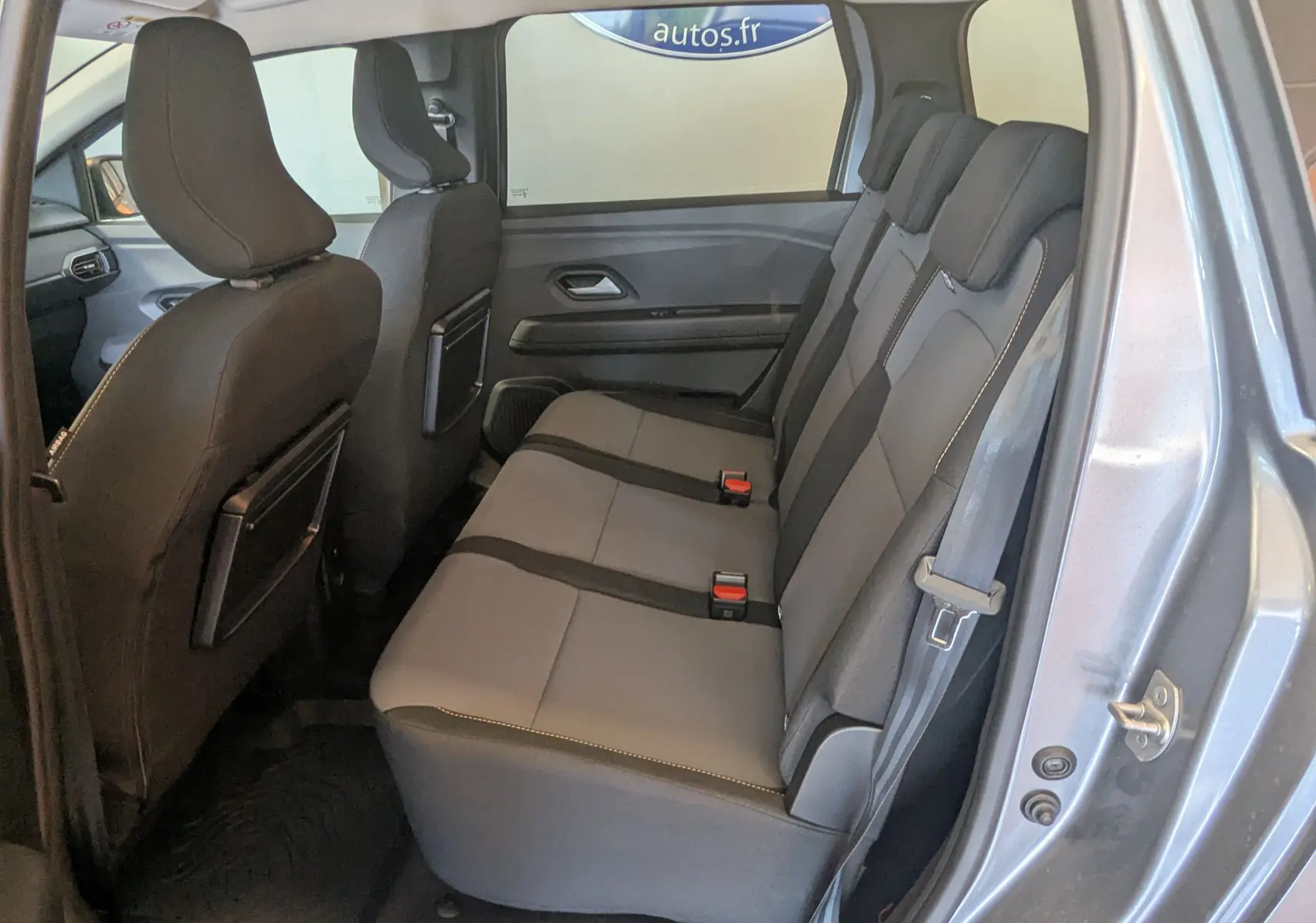 Vue intérieure côté droit sur les sièges arrière gris du Dacia Jogger 2026, version 7 places, avec ceintures visibles.