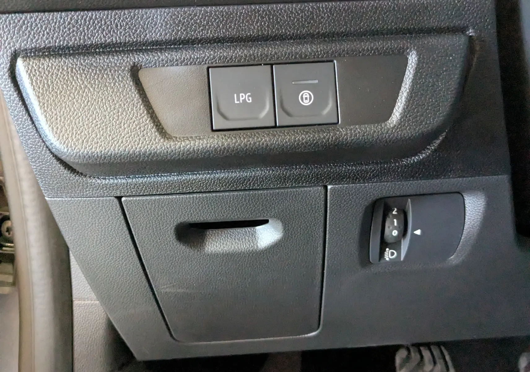 Détail intérieur montrant les boutons LPG et verrouillage sur le tableau de bord noir du Dacia Jogger 2026.