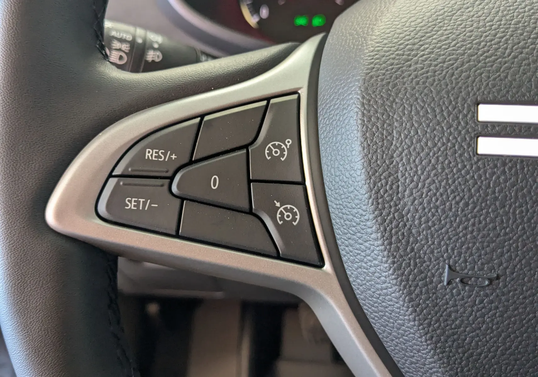 Gros plan sur les commandes de régulateur de vitesse au volant noir du Dacia Jogger gris schiste 2026.