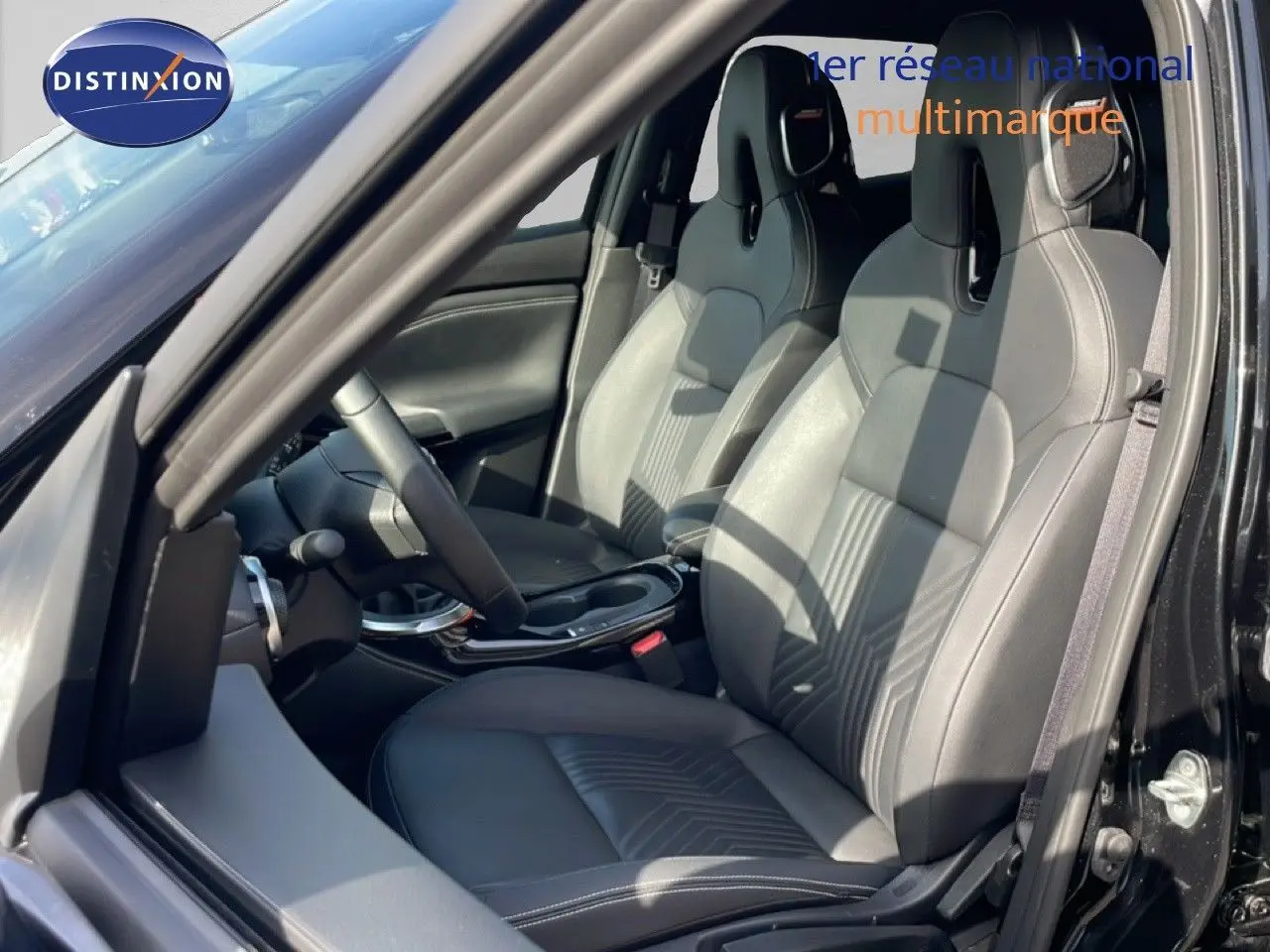 Vue intérieure côté conducteur du Nissan Juke noir Kuro Metal 2025, mettant en valeur les sièges en cuir et le volant multifonction.