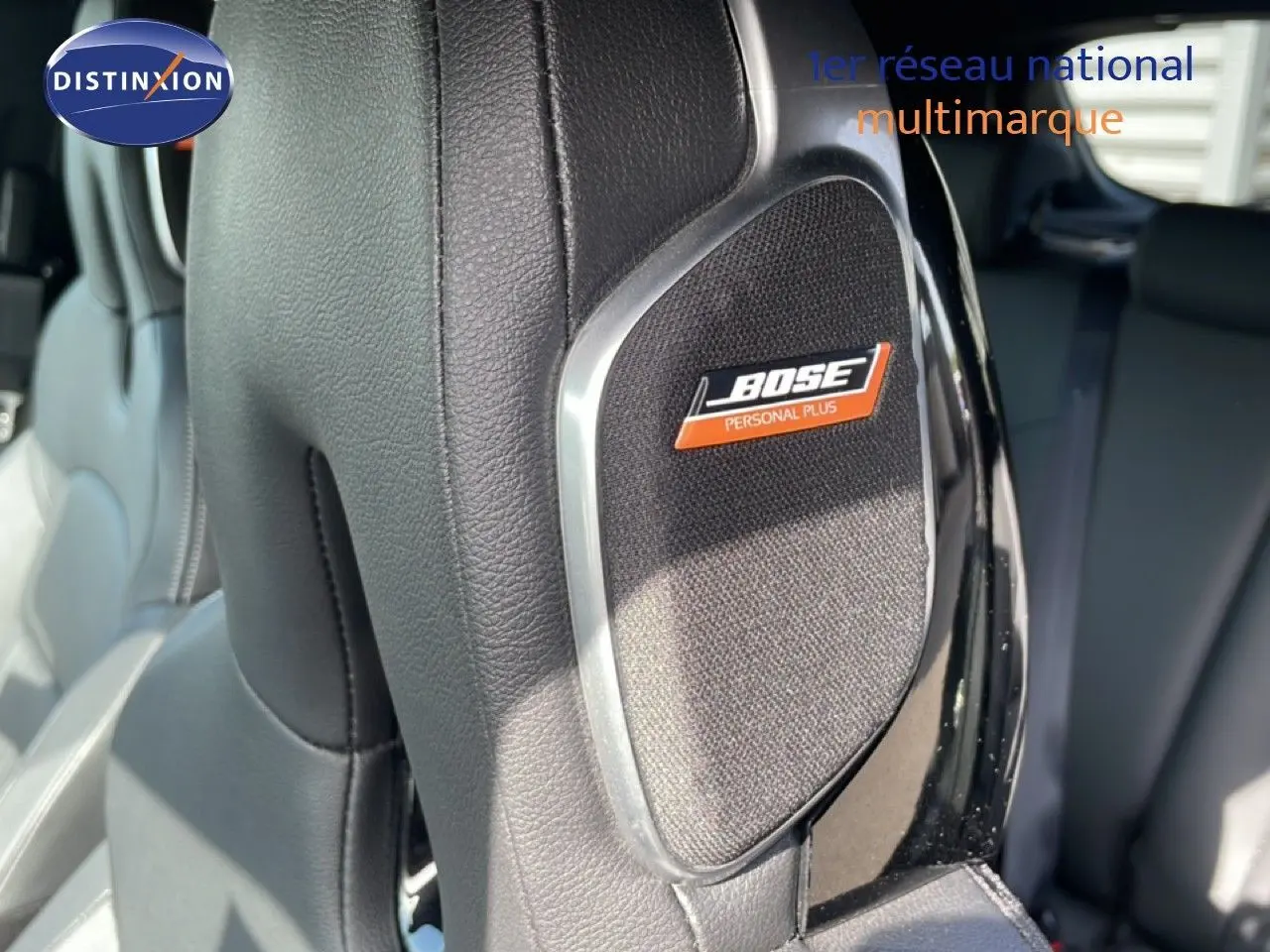 Détail du haut-parleur Bose intégré dans l'appui-tête en cuir noir du Nissan Juke 2025, version Tekna.