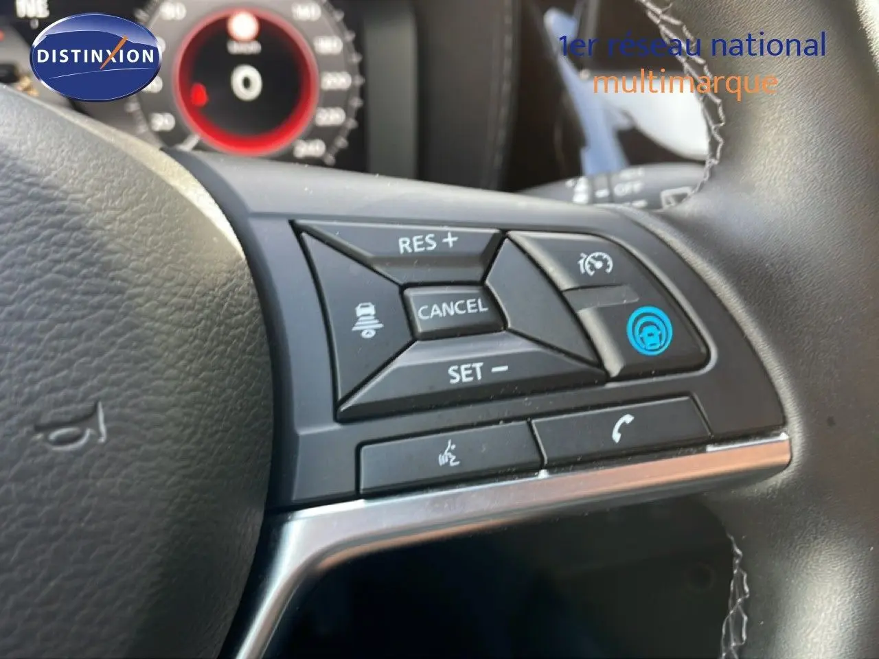 Gros plan sur les commandes au volant du Nissan Juke noir Kuro Metal, avec boutons de régulateur et appel téléphonique.