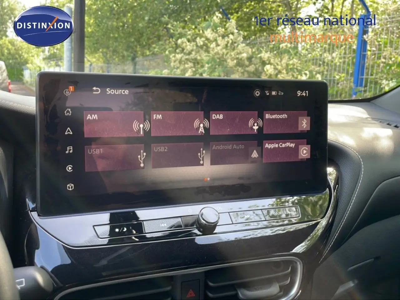 Écran tactile central du Nissan Juke 2025 affichant les options multimédias avec tableau de bord noir brillant.