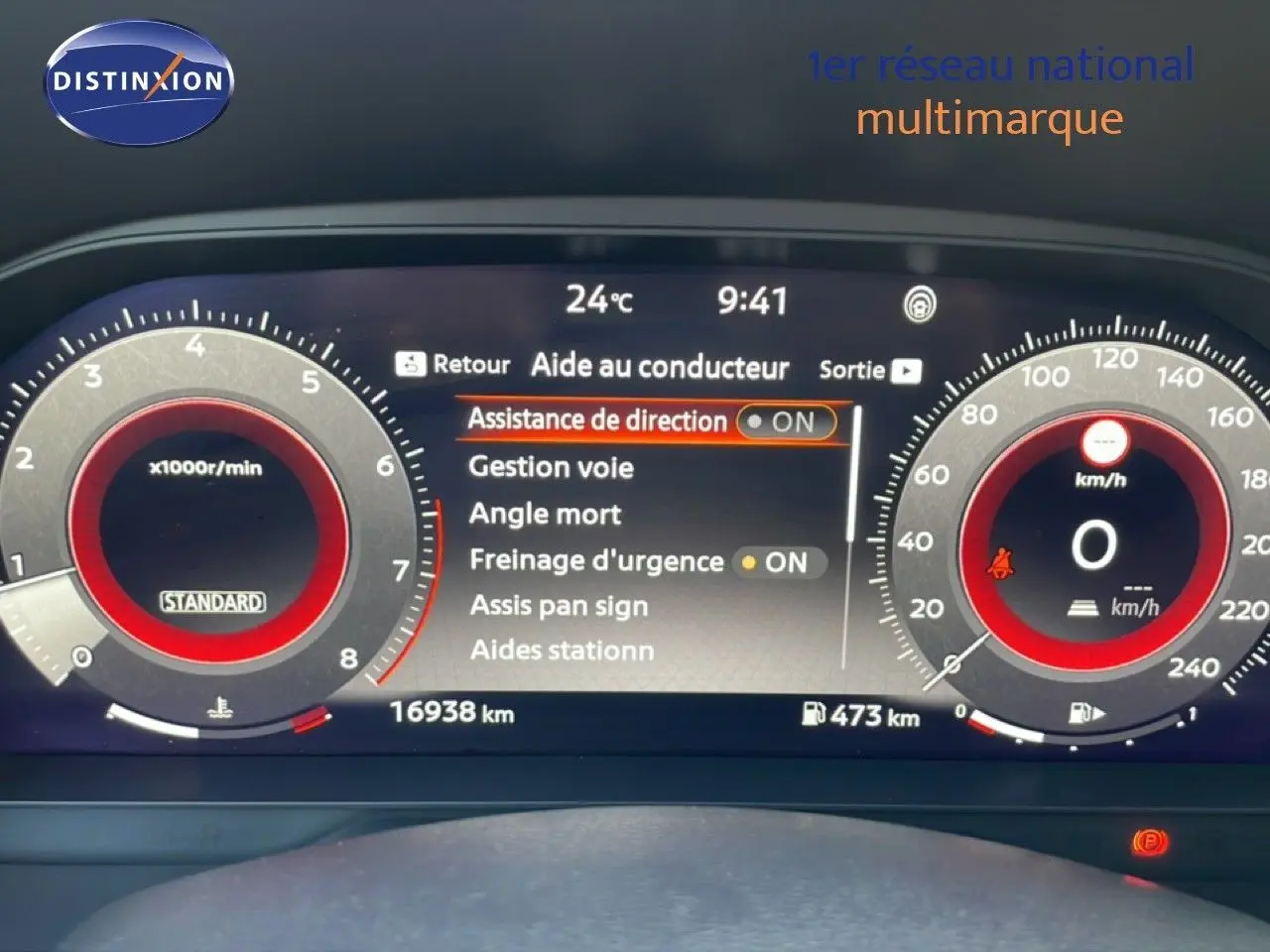 Tableau de bord numérique du Nissan Juke 2025, affichant les aides à la conduite et compteurs en rouge et gris.