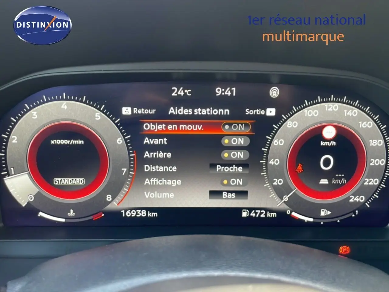 Tableau de bord numérique du Nissan Juke 2025 noir, affichant les aides au stationnement et compteurs à aiguille digitales.