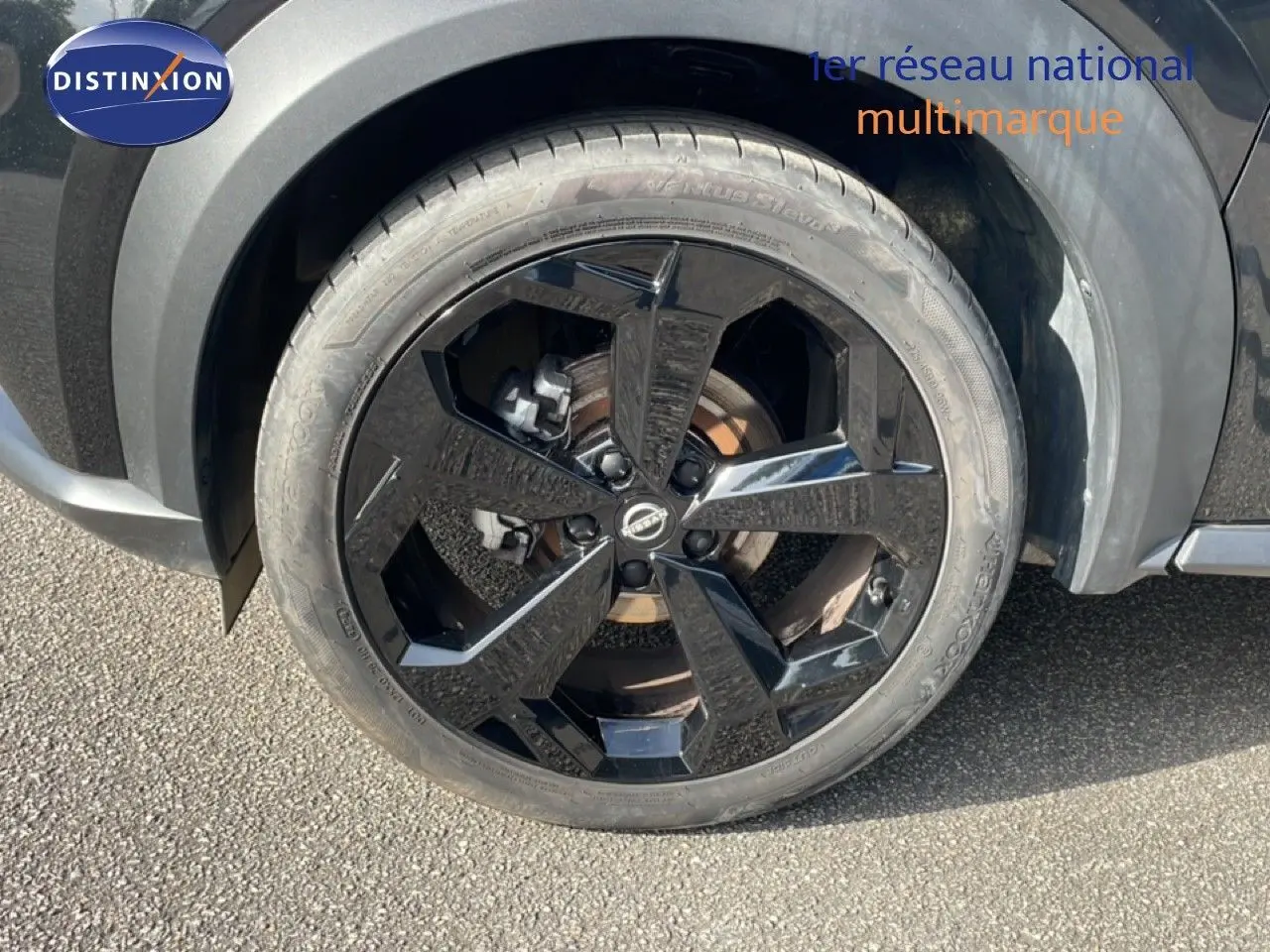 Gros plan sur la roue avant droite noire brillante du Nissan Juke 2025 noir Kuro Metal avec jante design.