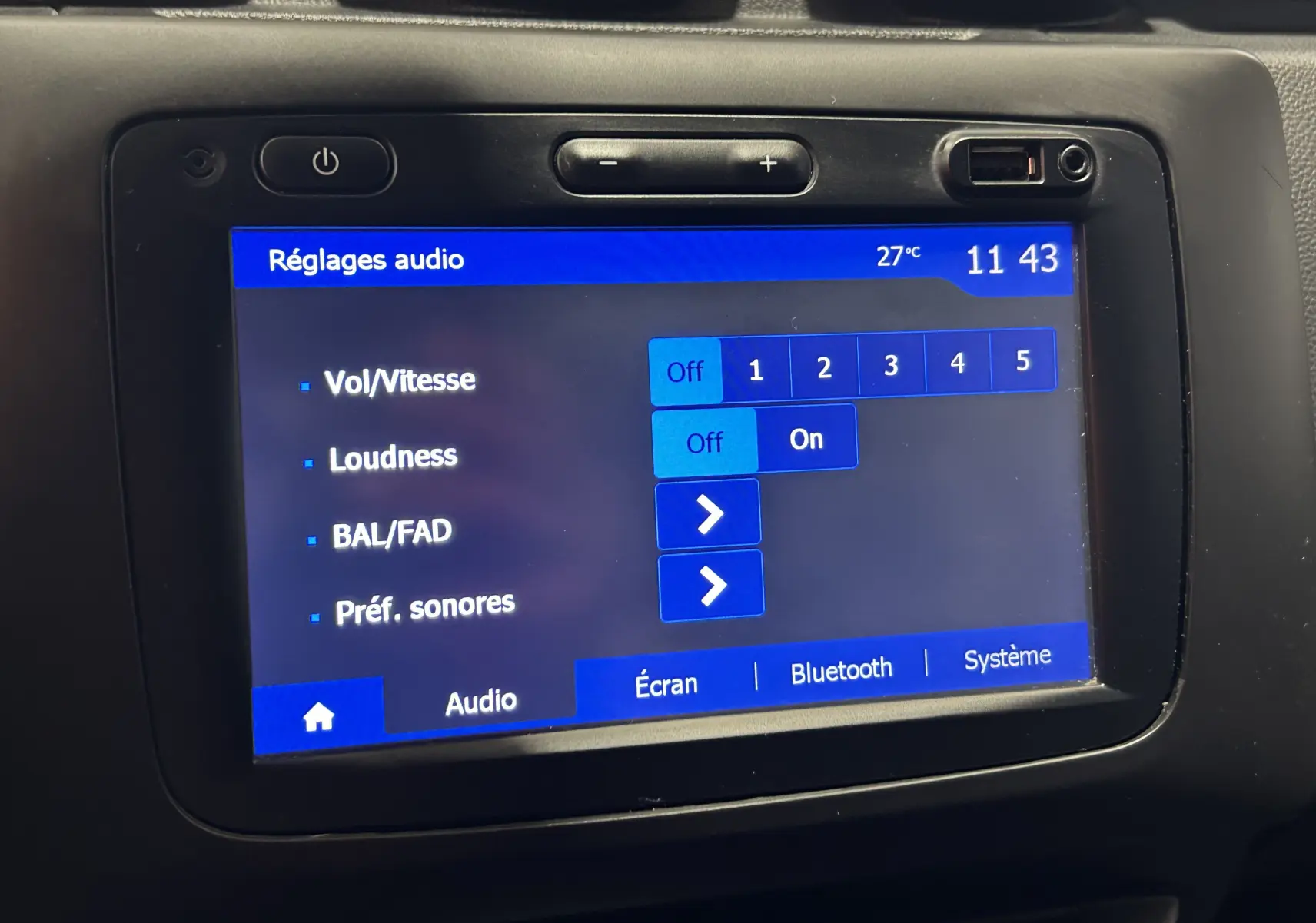 Écran tactile central du Dacia Duster 2018 affichant les réglages audio avec interface bleue et boutons de volume.
