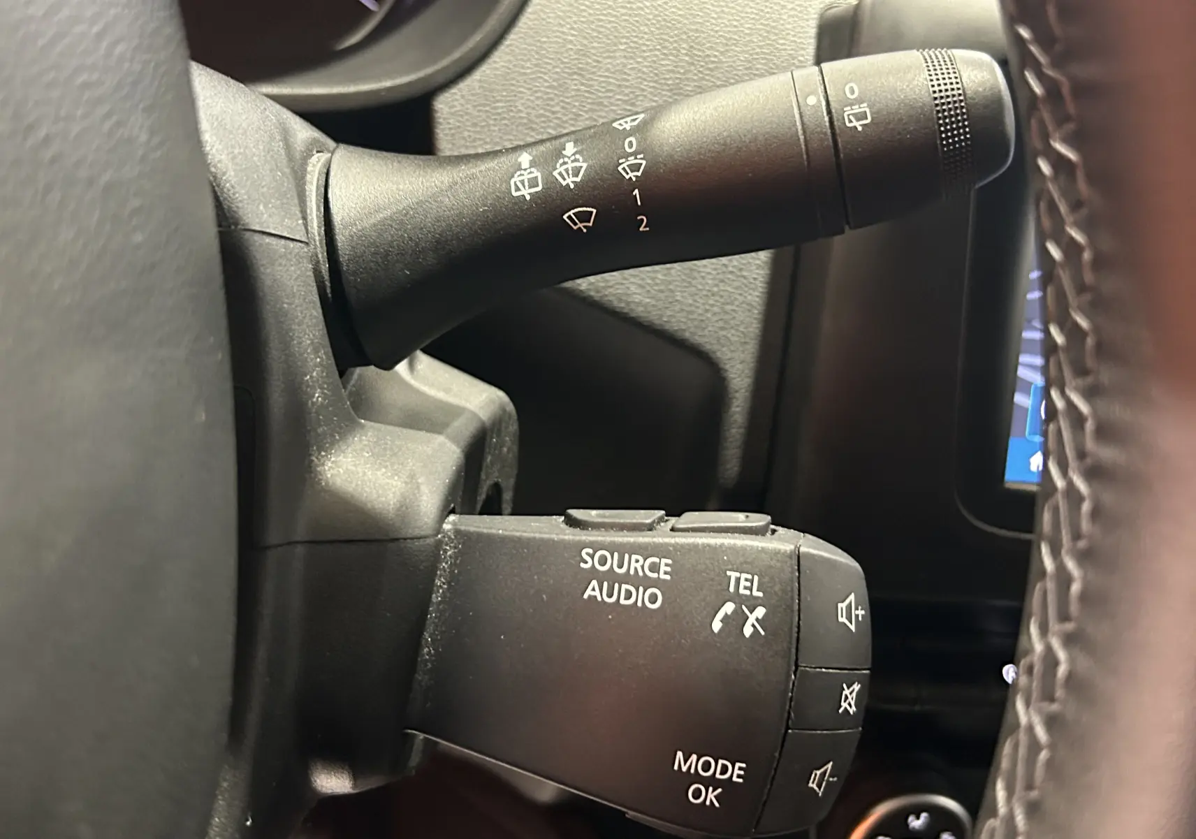 Gros plan sur la commande audio et essuie-glace côté gauche du tableau de bord du Dacia Duster noir 2018.