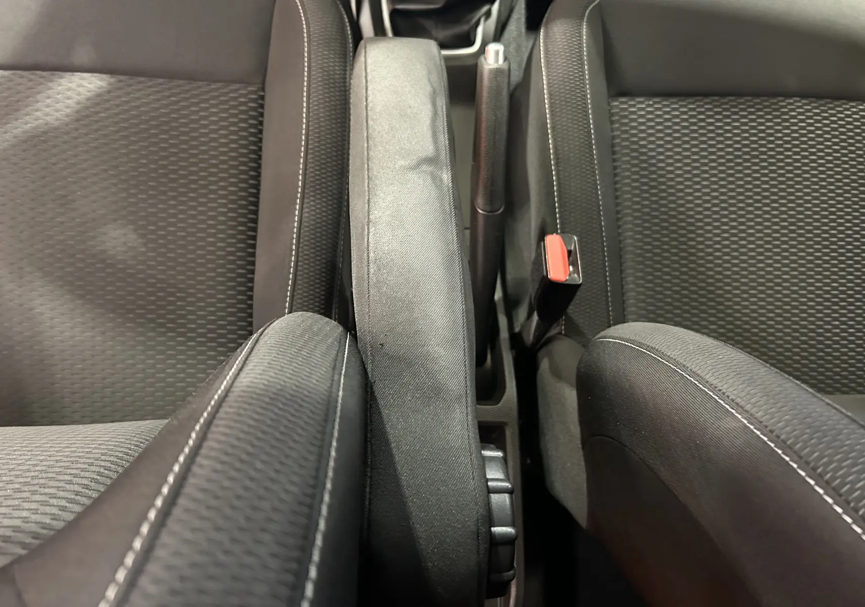 Vue rapprochée de l'accoudoir central et des sièges tissu noirs du Dacia Duster 2018, version Prestige.