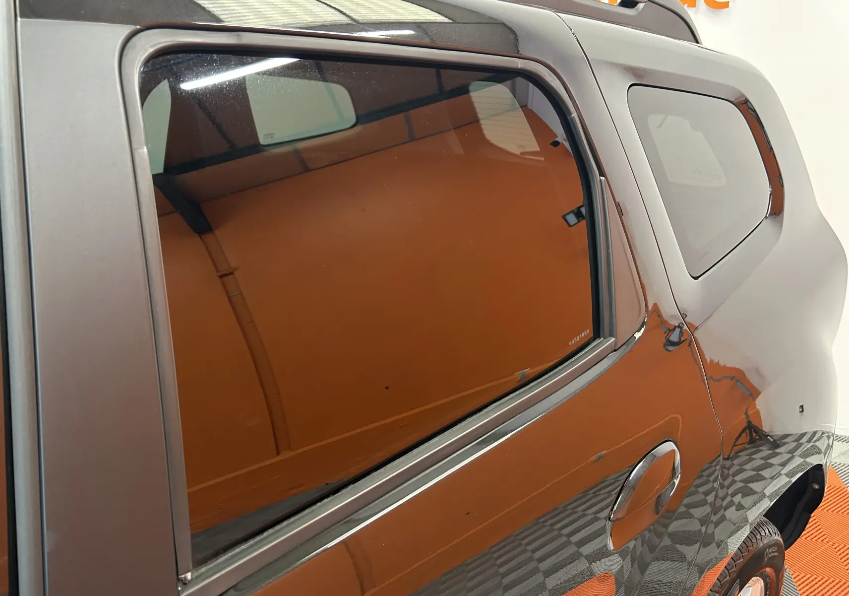 Vue latérale droite du Dacia Duster noir 2018, mettant en valeur la porte arrière et la vitre teintée.