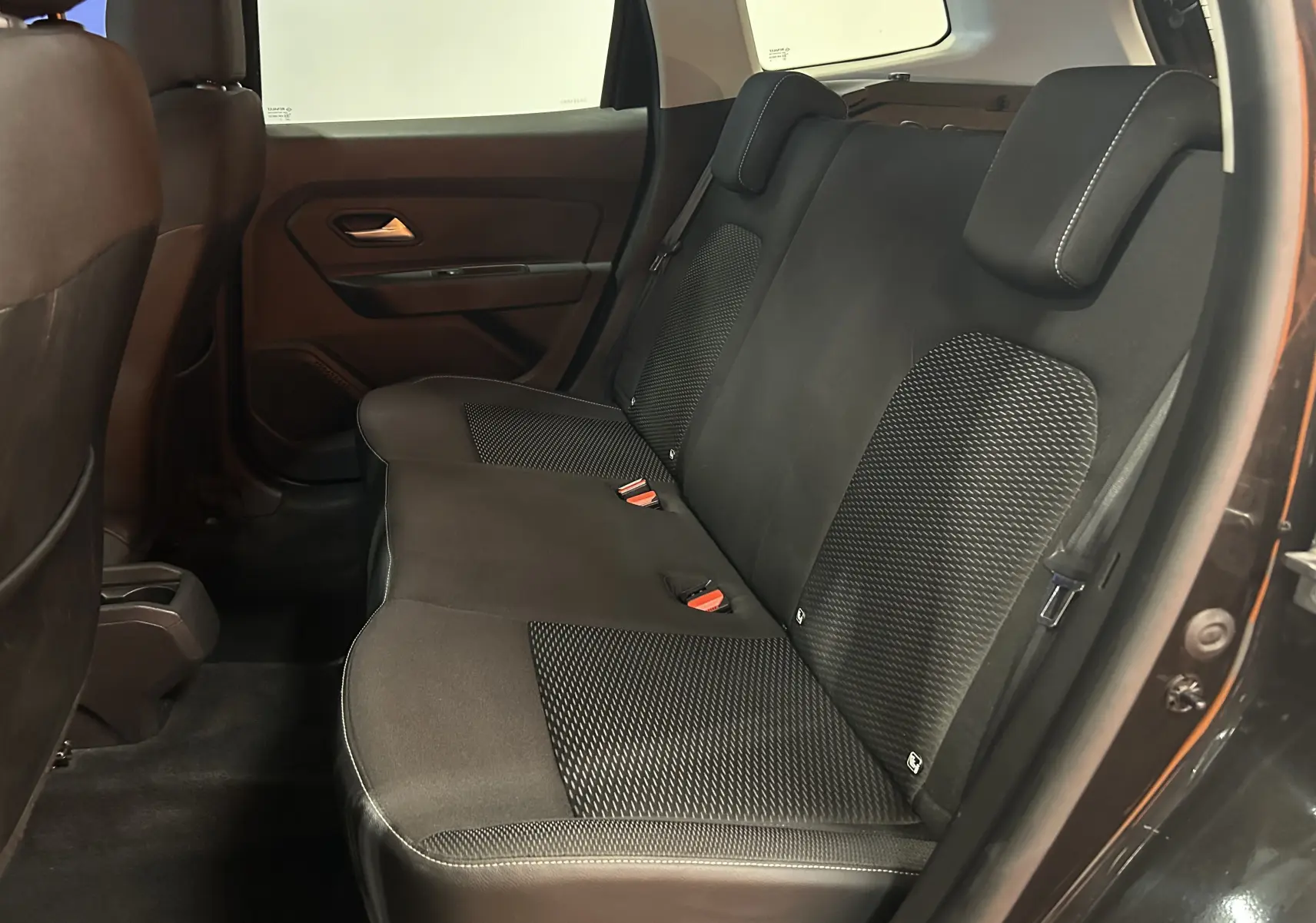 Vue intérieure côté droit des sièges arrière noirs en tissu du Dacia Duster 2018, avec appuie-têtes et ceinture de sécurité visibles.