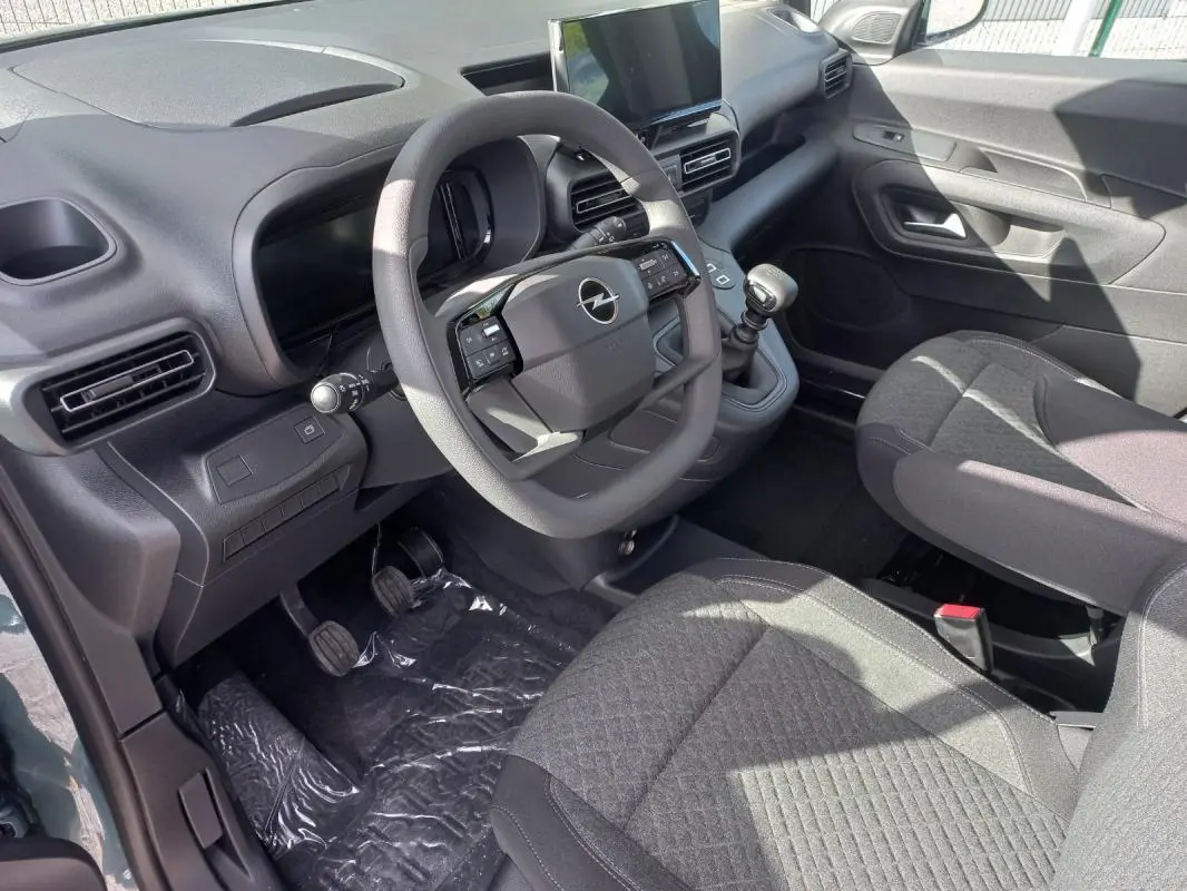 Vue intérieure côté conducteur de l’Opel Combo Life M 2025, avec volant, tableau de bord et sièges en tissu gris.