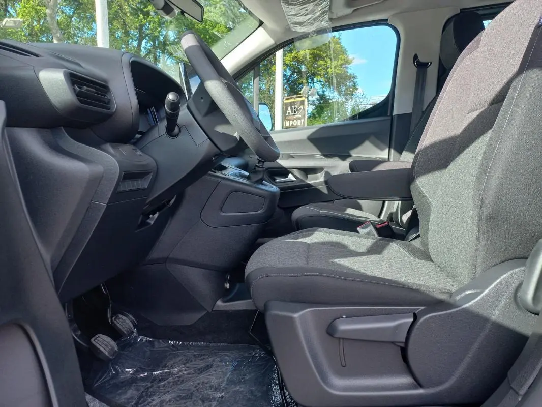 Vue intérieure côté conducteur de l’Opel Combo Life M 2025, sièges gris et tableau de bord noir simple.