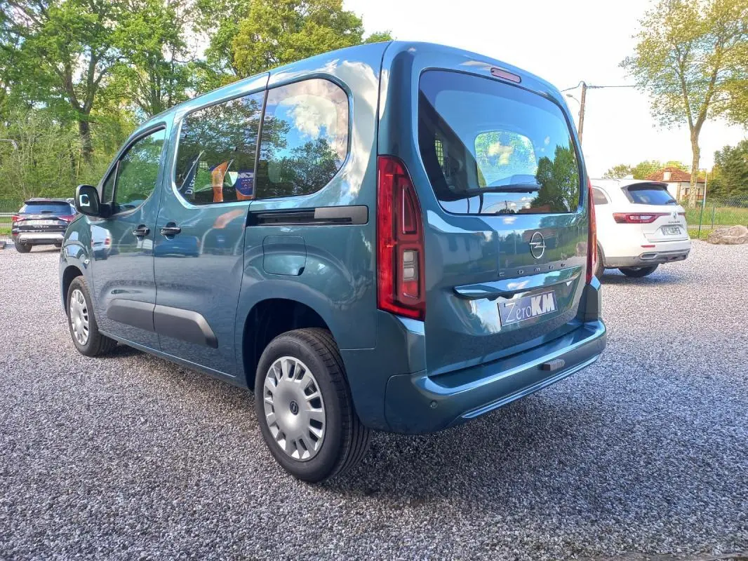Opel Combo Life bleu en vue 3/4 arrière droit, avec vitres latérales teintées et feux arrière verticaux rouges.
