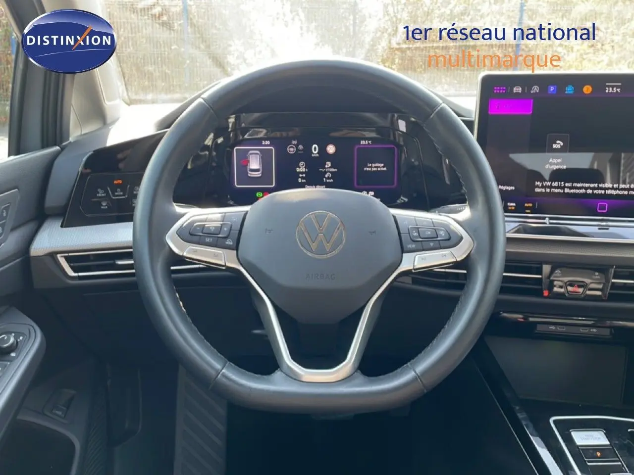 Vue intérieure centrée sur le volant noir et le tableau de bord digital du Volkswagen Golf SW VIII gris lunaire 2024.