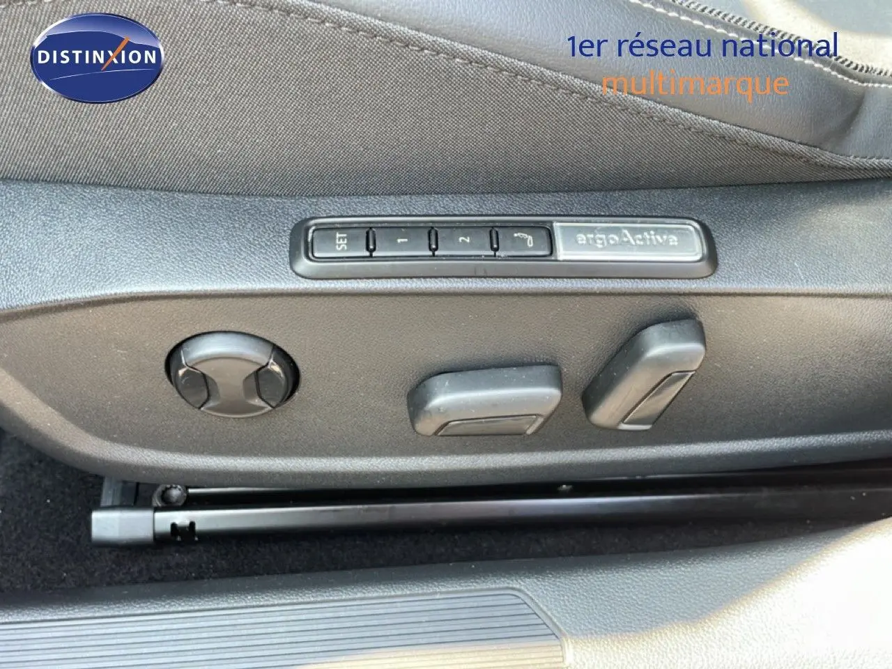 Gros plan sur les commandes de réglage électrique du siège conducteur de la Volkswagen Golf SW gris lunaire 2024.