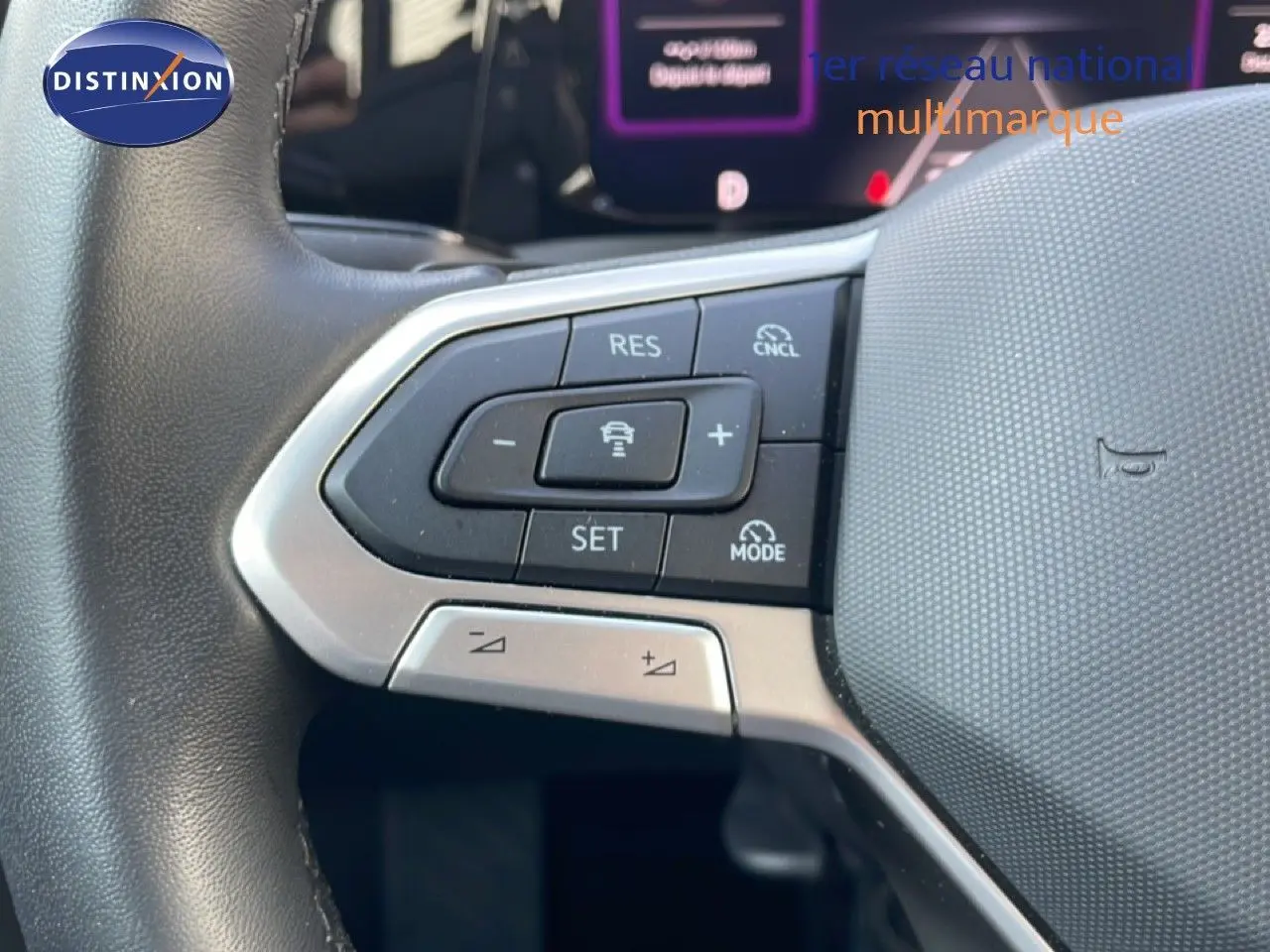 Gros plan sur les commandes de régulateur de vitesse au volant gris d’une Volkswagen Golf SW VIII 2024.