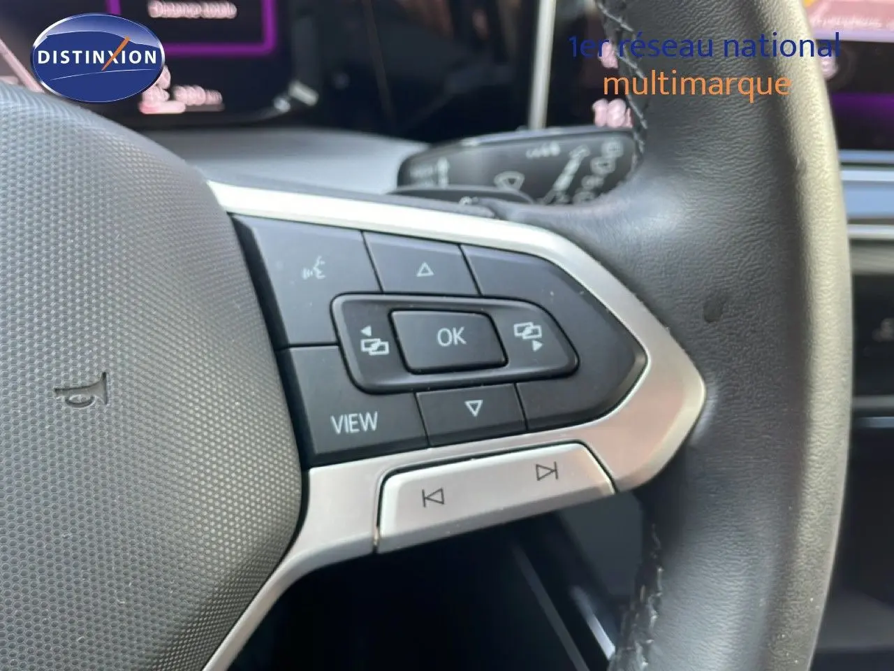 Gros plan sur les commandes au volant en cuir noir de la Volkswagen Golf SW VIII 2024, détails des boutons multifonctions.