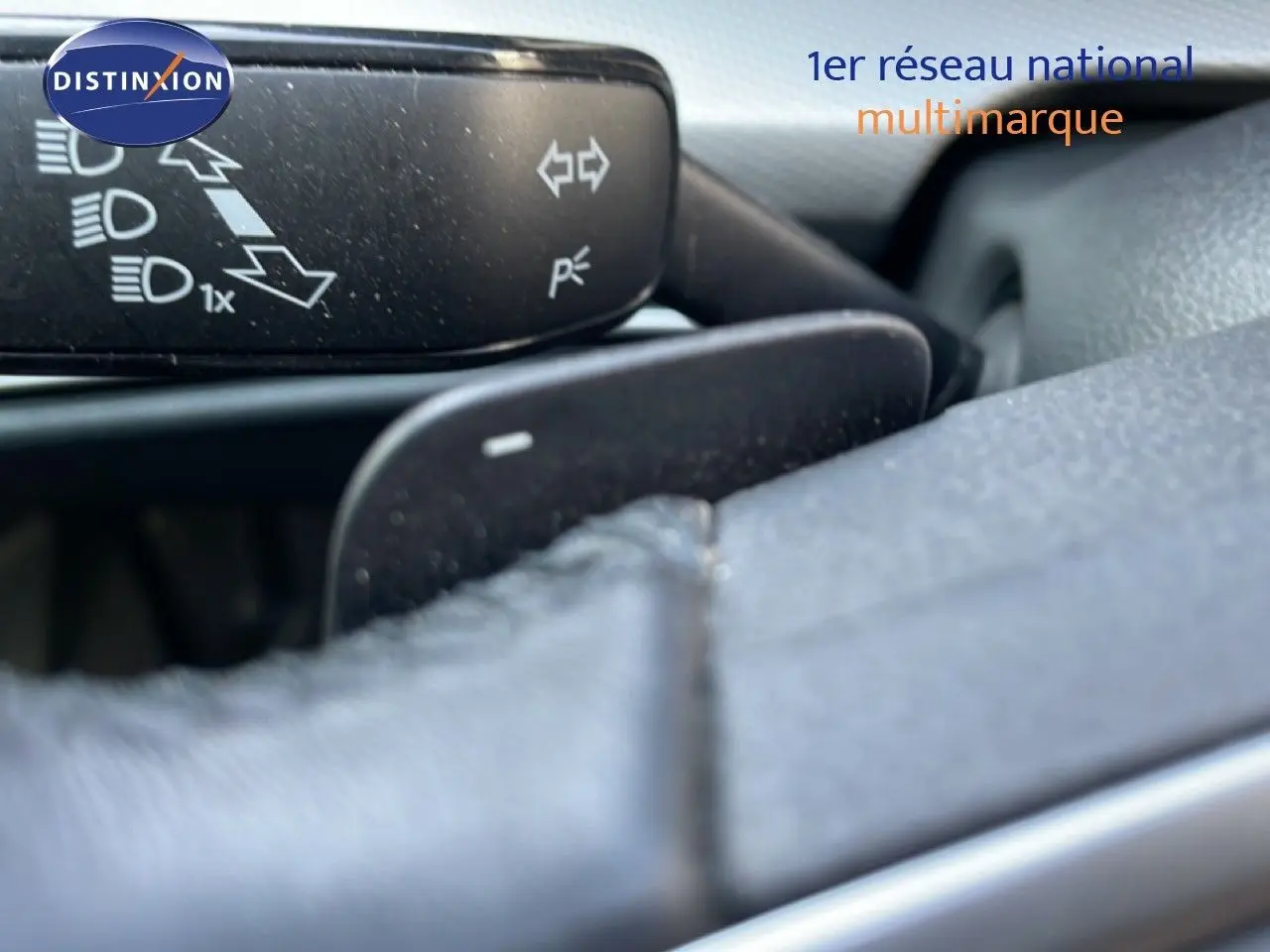 Détail du commodo de clignotant et feux sur le volant en cuir d'une Volkswagen Golf SW VIII 2024 gris lunaire métal.