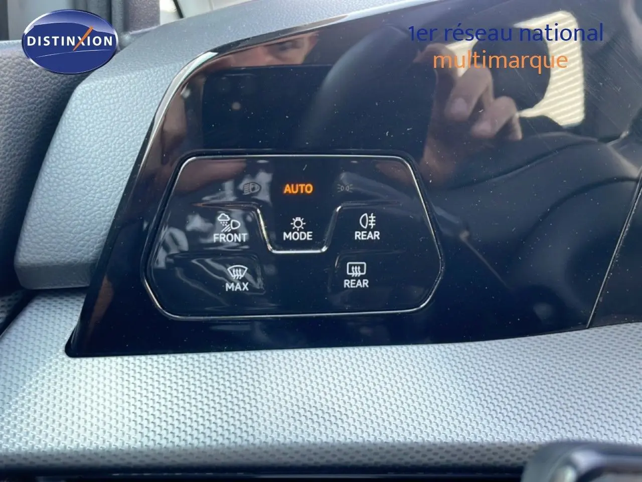Gros plan sur le tableau de bord noir brillant de la Volkswagen Golf SW VIII gris lunaire, affichant les commandes de climatisation.