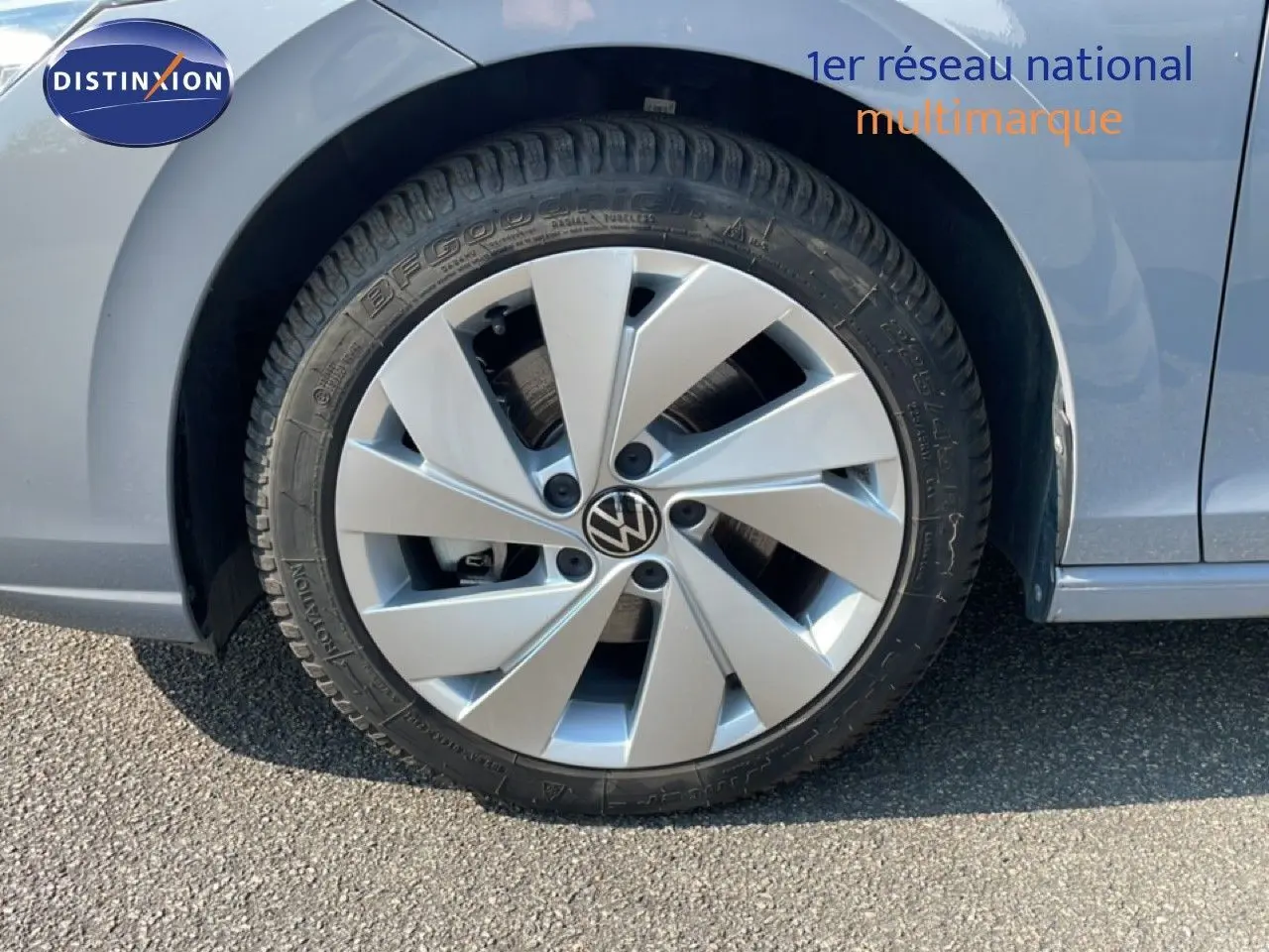 Gros plan sur la roue avant gauche d'une Volkswagen Golf SW VIII gris lunaire métal, jante alliage à cinq branches.