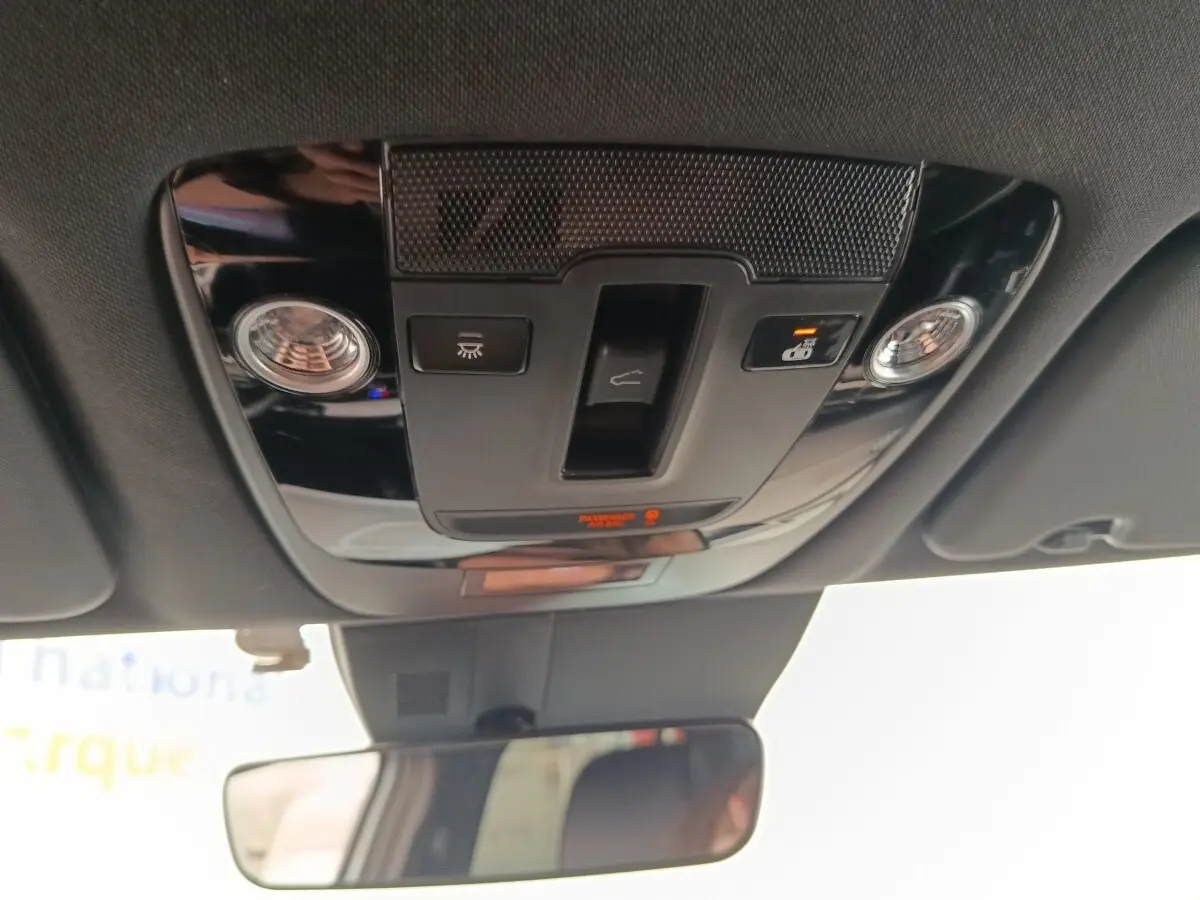 Vue intérieure du plafonnier noir avec commandes d’éclairage et rétroviseur intérieur d’un Kia Sportage gris clair 2022.
