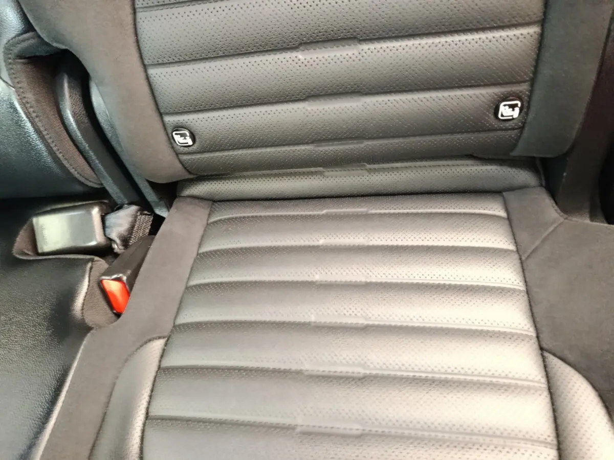 Gros plan sur l'assise arrière en cuir noir perforé du Kia Sportage 2022, avec fixation Isofix visible.