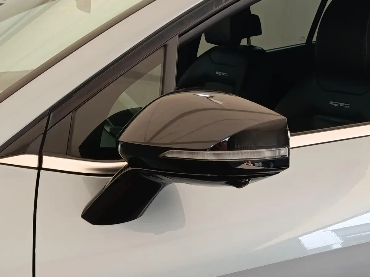 Gros plan sur le rétroviseur droit gris clair du Kia Sportage 2022 avec siège GT-Line visible en arrière-plan.