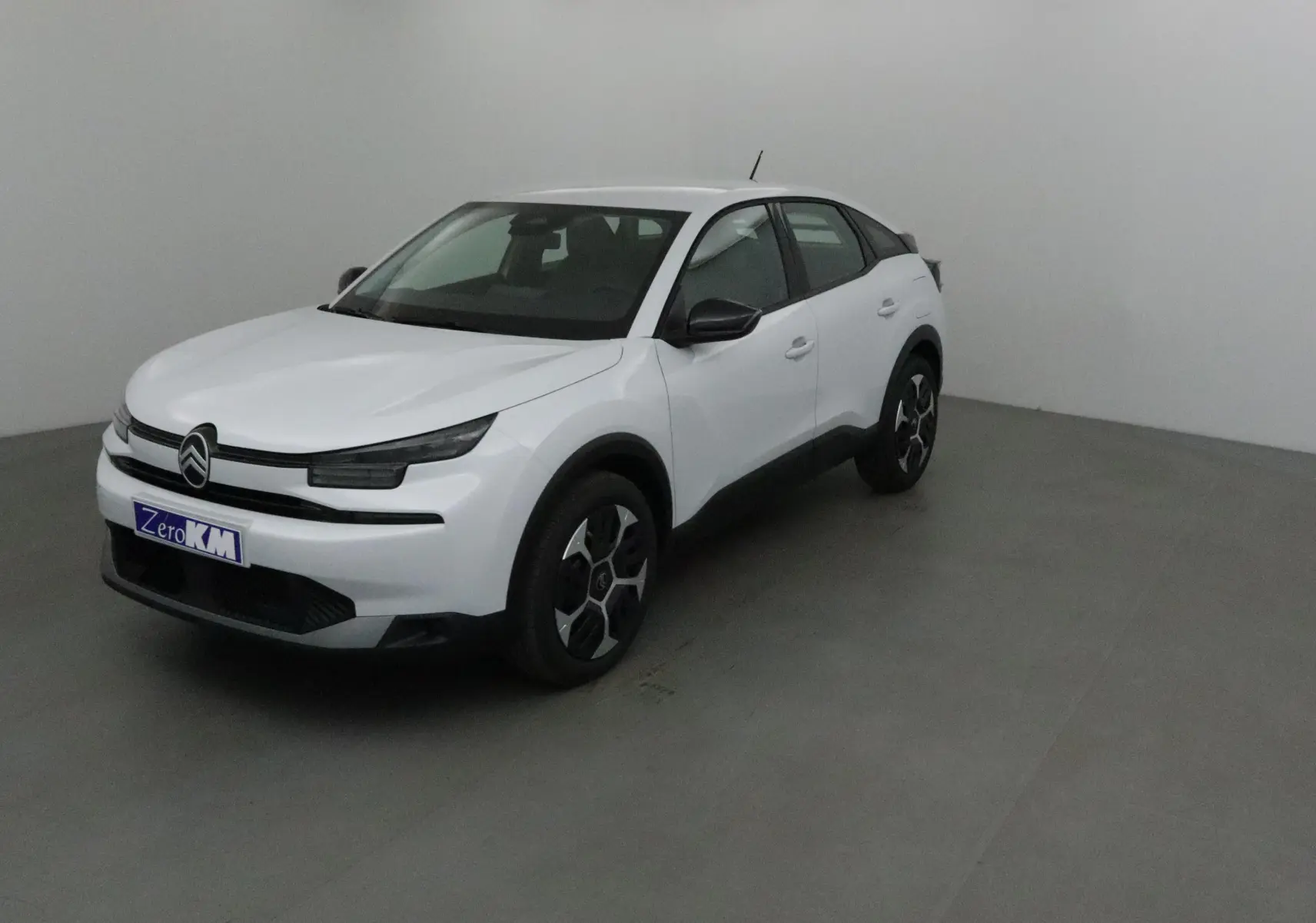 Citroën C4 blanc Okenite vue 3/4 avant droit, avec jantes noires et détails noirs contrastants.