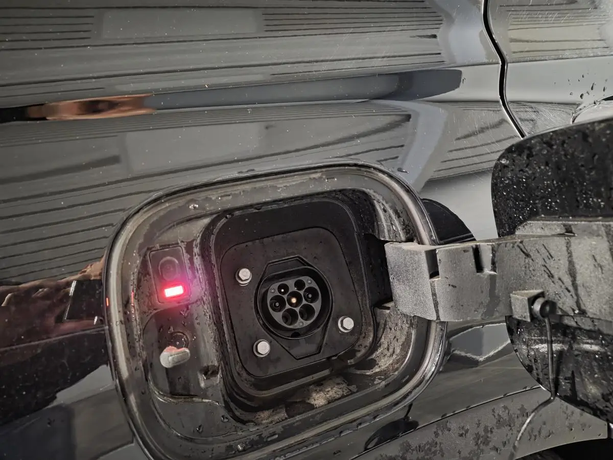 Prise de recharge hybride ouverte côté gauche sur Hyundai Santa Fé noir métallisé avec témoin lumineux rouge allumé